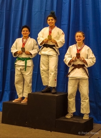 judo athletes pose at the podium for a picture after competition