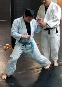 female judoka athlete being coached by male instructor